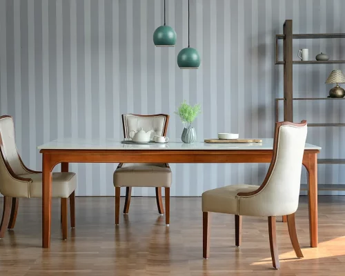 Elegant wooden dining table with a glass top, surrounded by four upholstered chairs with wooden legs.